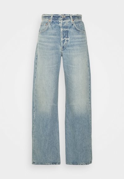 Gai zila denima bikses ar platu kāju dizainu, pie kurām ir augsts jostasvieta, piecas kabatas un viegla izbalēšana, demonstrējot klasisku teksturētu apdari.