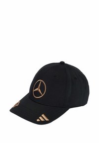 Čierna čiapka z látky s vyšívaným zlatým logom Mercedes na prednej strane a zlatými pruhmi Adidas na leme, štruktúrovaný dizajn.