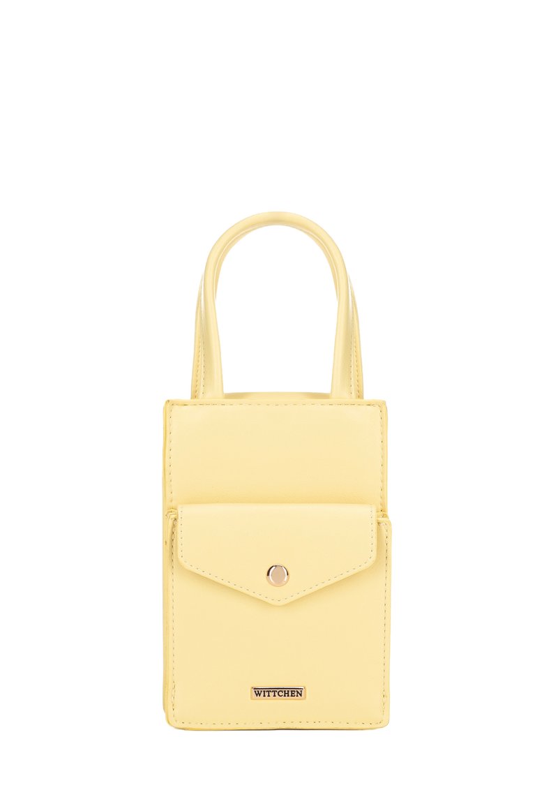 Sac à main en cuir vegan jaune avec deux poignées courtes, une poche à rabat à l'avant et une plaque logo dorée en bas. Forme rectangulaire simple.
