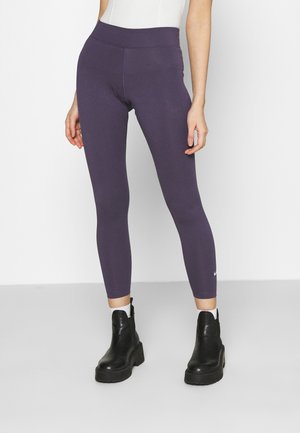 Leggings viola con vita alta, realizzati in materiale elastico. Presentano un piccolo logo bianco vicino alla caviglia e un design aderente.