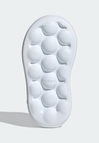 Vit Adidas-sula med en texturerad design som har rundade, upphöjda stödelement och en logotypprägling. Släta, böjda kanter.