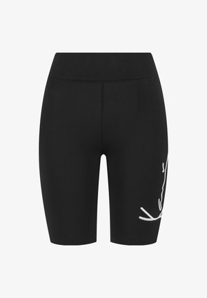 Cuissards de cyclisme noirs ajustés aux genoux avec une taille étroite et un logo blanc en écriture sur la cuisse droite.
