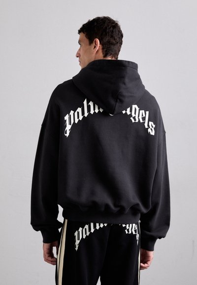 Felpa nera con cappuccio, dotata di un ampio logo bianco "palm angels" sulla schiena, caratterizzata da una vestibilità rilassata, tessuto texture e cappuccio con cordino.