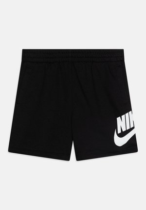 Fekete sportnadrág, pamut keverékből készült, rugalmas derékrésszel, két oldalsó zsebbel, és egy nagy fehér Nike logóval a bal lábon.