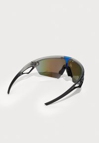 Sportsonnenbrille mit einem grauen und transparenten Rahmen, blauen Akzenten und einem Verlaufsglas. Sie verfügt über gebogene Bügel und ein aerodynamisches Design.