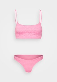 Conjunto de bikini rosa com um design drapeado, apresentando um top cropped com alças finas e um fundo de cintura baixa com um acabamento texturizado semelhante.