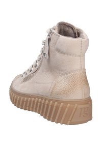 Beige läderankelboots med texturerade detaljer, en vadderad krage, silverdragkedja och en tjock, räfflad gummisula.