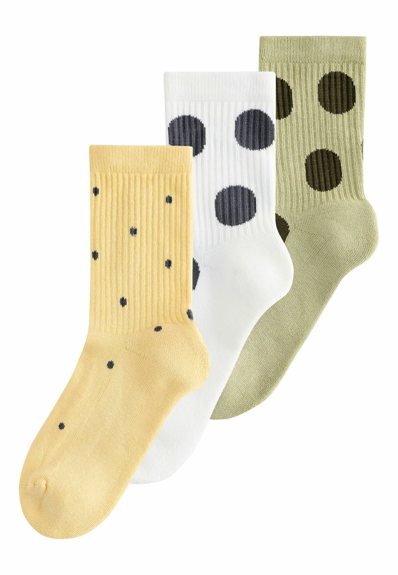 Tres pares de calcetines acanalados: uno amarillo con pequeños puntos negros, uno blanco con puntos negros más grandes y uno verde con puntos verde oscuro.