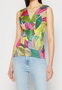 Haut sans manches multicolore avec un motif floral et de feuilles en rose, vert et jaune, doté d'un décolleté en V et d'une taille cintrée.