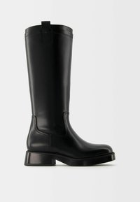 Bota negra de cuero alta con un tacón bajo en bloque y una pestaña en la parte superior, mostrada en un perfil lateral derecho sobre un fondo liso.