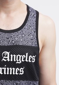 Top negro sin mangas con un patrón de paisley en gris y blanco, con una textura de malla y un texto en negrita que dice "Los Angeles Grimes" en blanco.
