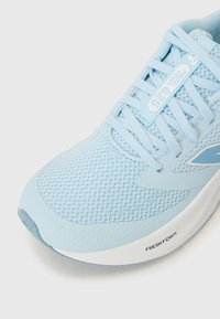 Baskets de course bleu clair avec des détails en maille, des lacets et un logo sur le côté. Accent sur le confort et les caractéristiques de respirabilité.
