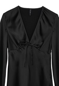 Blouse en satin noir avec un décolleté en V, des manches longues et des détails froncés au niveau de la poitrine mettant en valeur un nœud tied. Texture lisse.