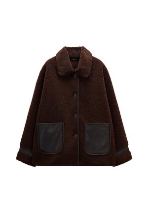 Brązowa kurtka z polaru z zapięciem na guziki, dużymi skórzanymi kieszeniami, kołnierzem i kontrastowymi skórzanymi akcentami na rękawach. Miękka tekstura.