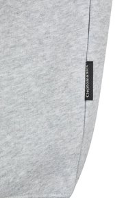 Gray sweatshirt fabric with a soft texture; features a small black label on the side with "Cleptomanicx" printed in white.