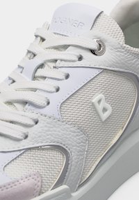 Λευκό αθλητικό παπούτσι με υφαντό πλέγμα και δερμάτινα πάνελ, λευκά κορδόνια, ασημένιες τρύπες για τα κορδόνια και ανάγλυφο λογότυπο "B" στο πλάι.