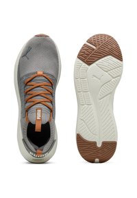 Puma Sneakers mit einem grauen Mesh-Obermaterial, orangefarbenen Schnürsenkeln und einer weißen und braunen Gummisohle. Verfügt über eine Zuglasche für einfaches Anziehen.
