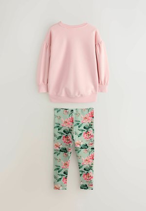 Heled roosa softsärk, millel on puffvarrukad ja ümmargune kaelus, koos roheliste legginsitega, millel on suured roosad lillemustrid ja rohelised lehed.