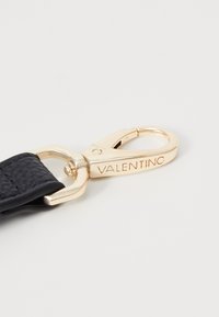Black leather strap with a gold metal clasp featuring "Valentino" engraved. Smooth texture with a sturdy design and secure closure mechanism.