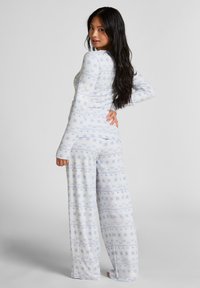 Piżama z długim rękawem w jasnoniebieskim kolorze z kwiatowym wzorem. Bluzka dobrze przylega, natomiast spodnie są luźne i zwiewne.