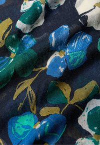Blumenstoff mit blauen und grünen Blumen und gelben Akzenten auf einem dunklen Marine-Hintergrund. Strukturierter, leichter Stoff mit sanftem Fall.