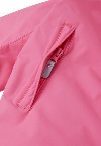 Jasnoróżowy materiał odzieżowy zewnętrzny z kieszenią na zamek błyskawiczny, charakteryzujący się gładką teksturą i dopasowanym suwakiem.