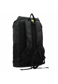 Mochila negra con correas acolchadas, un exterior suave, cierre de cremallera con acentos verdes y bolsillos laterales de malla para almacenamiento adicional.