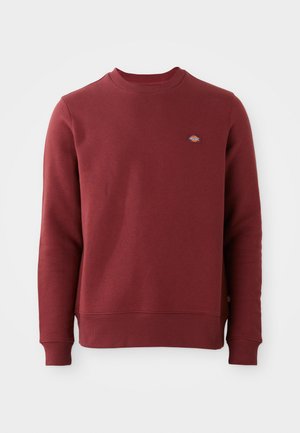 Bordeaux sweatshirt gemaakt van een katoenmengsel. Heeft een geribbelde ronde hals, elastische manchetten en een klein merkembleem op de borst.