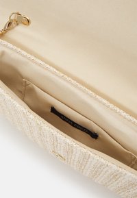 Pochette beige tissée avec un extérieur en tissu texturé, une quincaillerie dorée et un intérieur beige clair avec une poche pour étiquette.