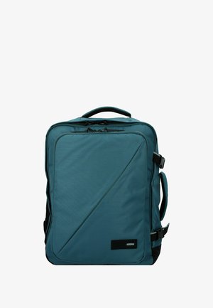 Sac à dos teal avec une surface texturée, présentant un design diagonal, une poignée supérieure, une sangle ajustable et une poche zippée à l'avant.