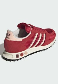 Κόκκινα και ροζ sneakers Adidas LA Trainer με επάνω μέρος από δίχτυ και σουέτ, τρεις ρίγες στο πλάι και υφή από καουτσούκ στην εξωτερική σόλα.