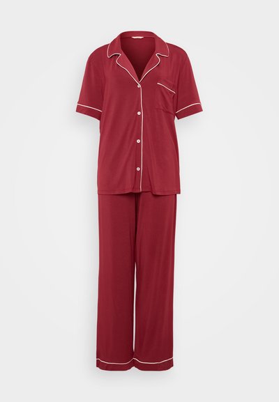 Red pajama set made of soft fabric, featuring a collared short-sleeve top with white piping and chest pocket, paired with matching wide-leg pants.