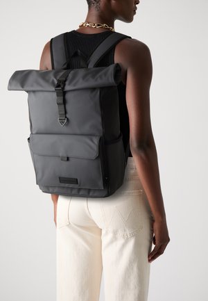 Black roll-top backpack made of smooth material with adjustable straps, front pocket, and a minimalist design.