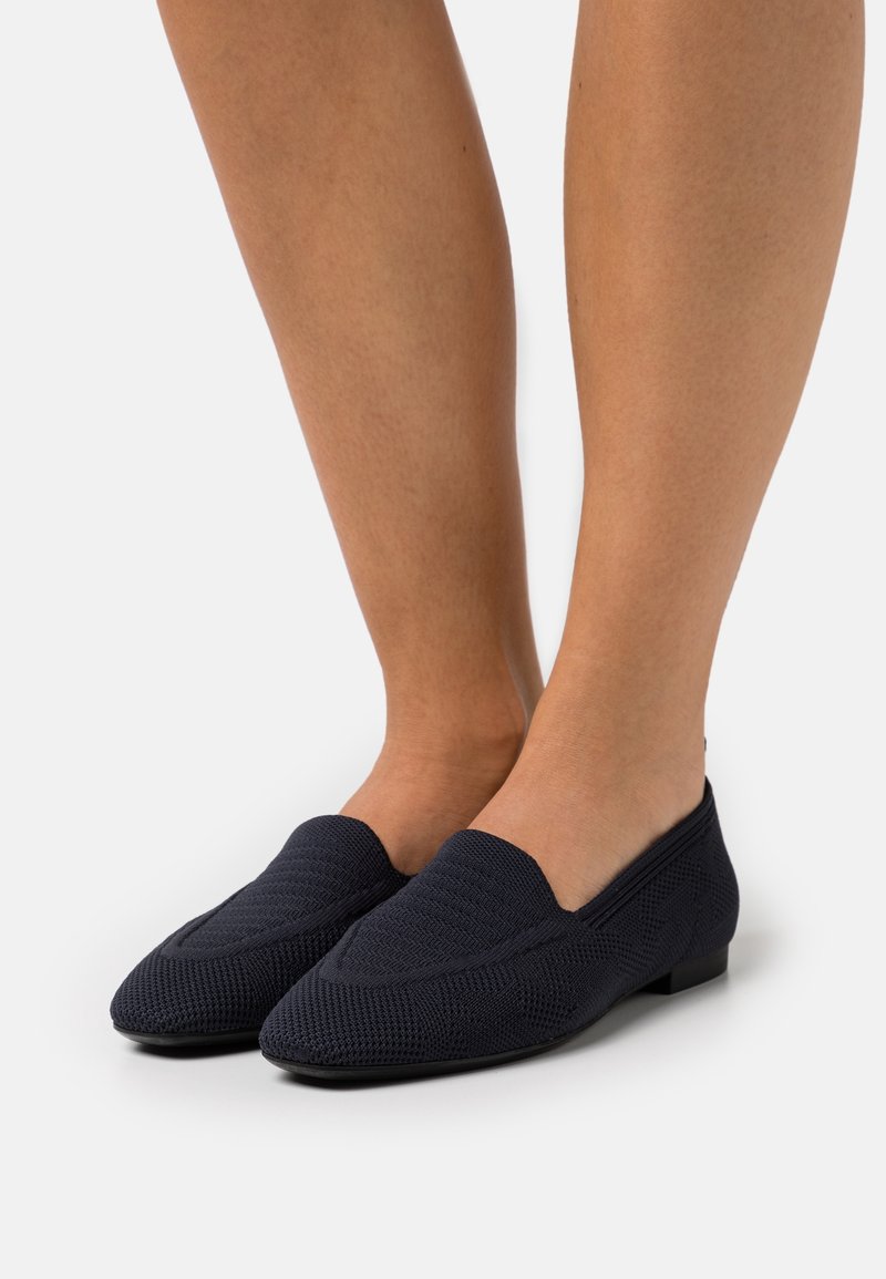 Mocassins en maille bleu marine avec un motif texturé, bout arrondi et petit talon plat. Matière souple offrant confort pour un usage décontracté.
