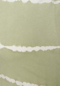 Tecido verde com um padrão tie-dye apresentando riscas brancas. A textura é suave e elástica, adequada para vestuário casual.