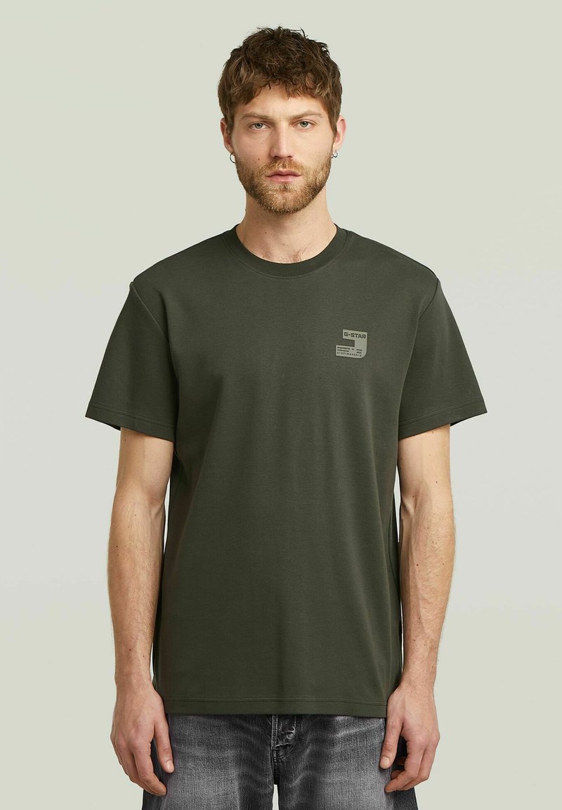 Olijfgroene t-shirt van katoen, met een ronde hals en korte mouwen. Bevat een klein logotag op de linkerborst. Klassieke pasvorm.