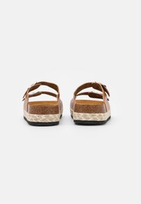 Bruine sandalen met twee verstelbare banden, kurken voetbed en gevlochten jute tussenzool. Zwarte rubberen buitenzool zorgt voor grip.
