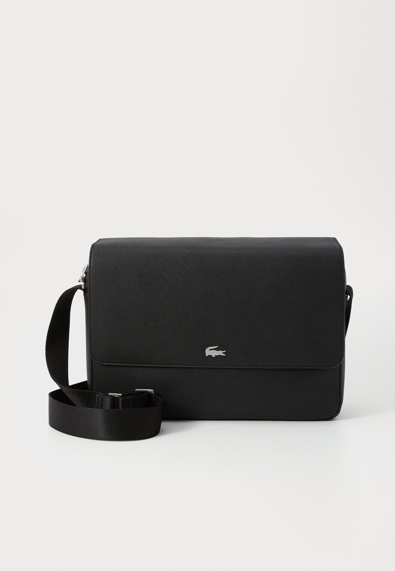 Sac en cuir noir à bandoulière avec une texture lisse, un rabat avant, un accent logo argenté et une bandoulière en tissu réglable.