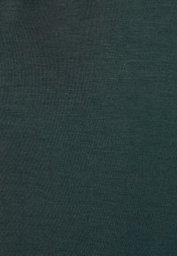 Tessuto di cotone verde scuro con una superficie liscia e leggermente strutturata, caratterizzato da un motivo a coste, che presenta una colorazione e una consistenza uniforme.
