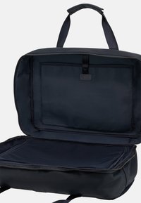 Borsa da viaggio in nylon nero con cerniera, aperta per rivelare un interno spazioso, dotata di una tasca in rete e di un compartimento piatto per l'organizzazione.