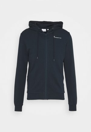 Sudadera con capucha azul marino con cremallera, bolsillos delanteros, capucha con cordón, puños acanalados y pequeño logo blanco en el pecho izquierdo.