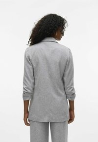 Blazer gris texturizado con mangas enrolladas y cuello con muesca, que presenta un corte entallado y un diseño de espalda recta. Sin logotipos ni acentos visibles.