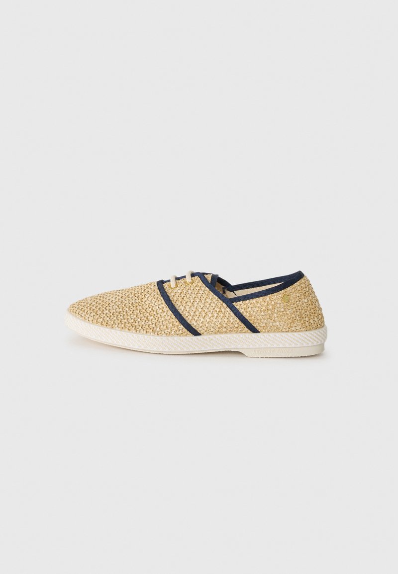 Beige woven shoes with dark blue accents, rounded toe, and white rubber sole. Features two eyelets for laces and a textured surface.