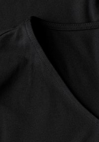 Top de algodón negro sin mangas con un profundo escote en V, textura suave y costuras reforzadas en los bordes para mayor durabilidad.