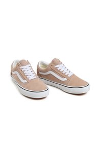 Beżowe zamszowe trampki z białymi sznurowadłami i bocznym pasem, z zaokrąglonym noskiem i gumową podeszwą z czarnymi akcentami.