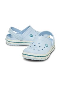 Helle blaue Clogs aus Kunststoff mit Belüftungsöffnungen, weißer Sohle mit grünen und blauen Sprenkeln, verstellbarem Fersenriemen und Logo-Detail.