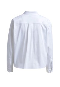 White long-sleeve shirt with a classic collar, back pleat detail, buttoned cuffs, and smooth texture, designed for a relaxed fit.