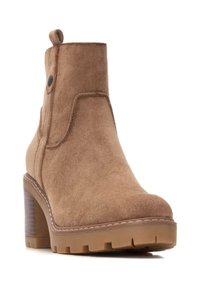 Stivale alla caviglia in suede beige con tacco a blocco, pannello laterale testurizzato, linguetta posteriore e suola in gomma con motivo di battistrada per la presa.