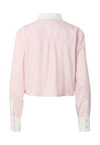 Chemise courte à manches longues rose clair avec col et poignets blancs, présentant des rayures diagonales subtiles et une petite couture décorative sur le haut du dos.