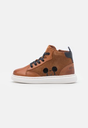 Brun høj top sneaker med sorte snørebånd, hvid sål, ruskind og læderpaneler med et diskret Mickey Mouse ansigt på siden.